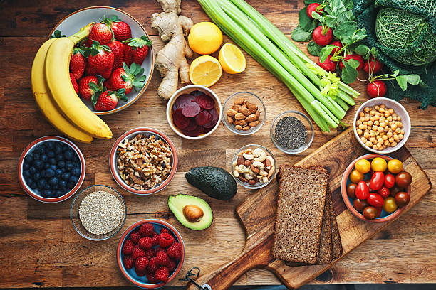 Fresh colorful vegetables and whole grains arranged on a wooden table